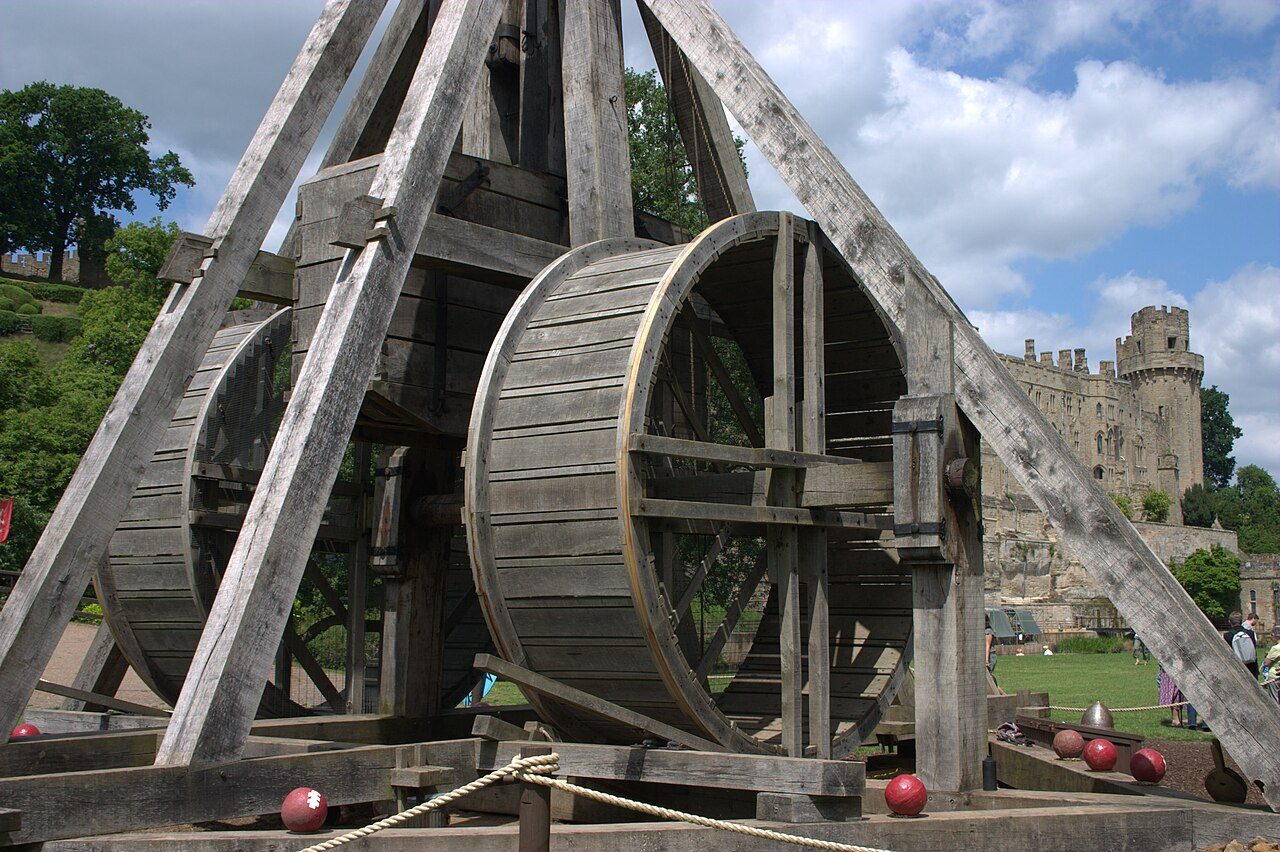 The treadwheels of the Warwick Castle trebuchet with the castle behind